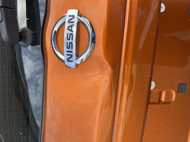 Orange rear hatch with a dent crossing the body line