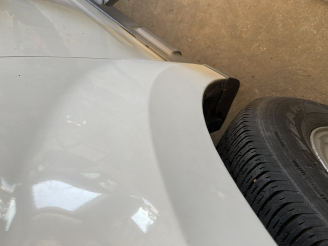White front fender after repair around the wheel arch